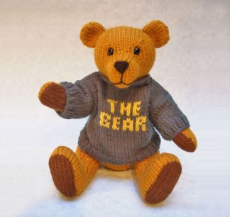 knitted toy of a teddy bear with a jumper with The Bear written on