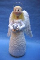 knitted toy of an angel in white holding a dove