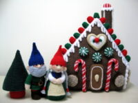 knitted toys of a gnome couple outside their gnome house