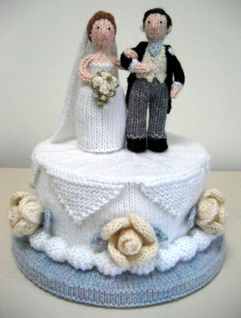 knitted toy of a wedding couple on top of a wedding cake