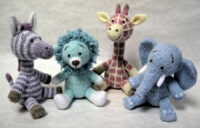 knitted toys of a zebra, lion, giraffe and elephant