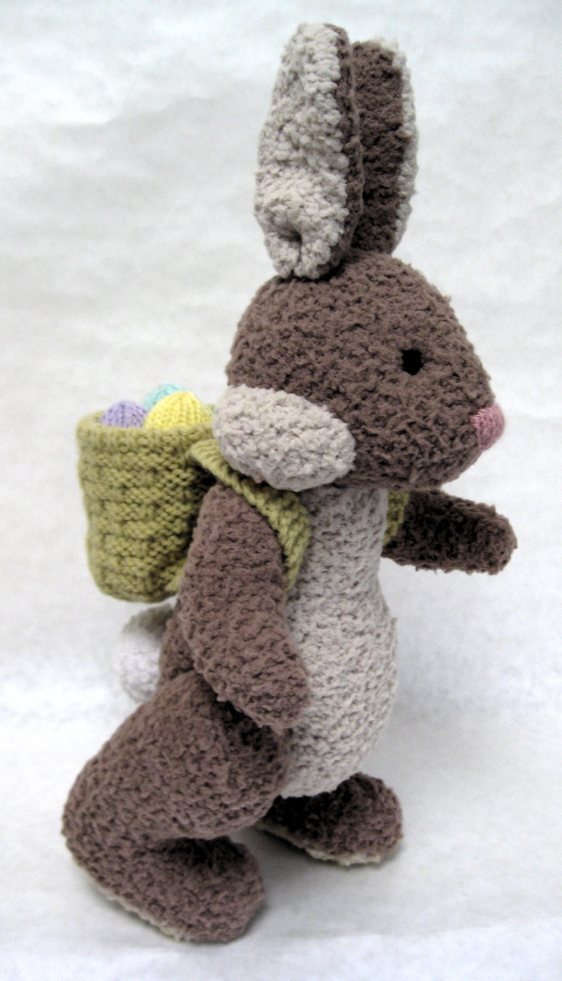 Knitted toy of the Easter bunny carrying a sack of eggs