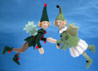 knitted toys of girl and boy elf dressed in woodland green