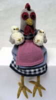 knitted toys of a hen in a pinny with two little chicks on her knees