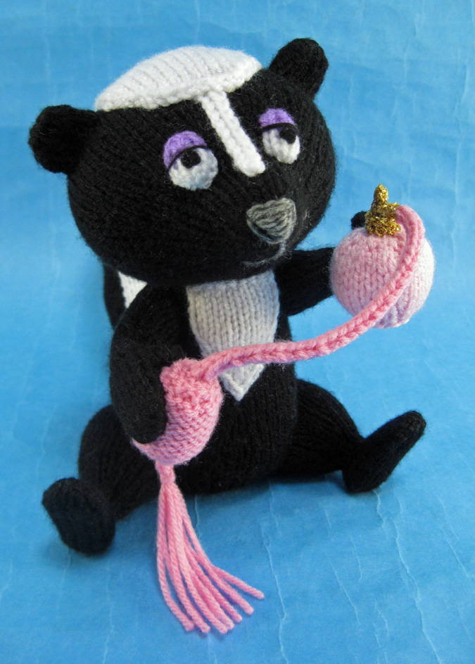 knitted toy of a skunk with a perfume spray