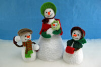 knitted toys of a group of snow characters, one a mother and 2 children