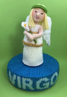 knitted toy of a young woman on a plinth with Virgo on it